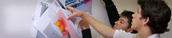 students looking at work pinned to board